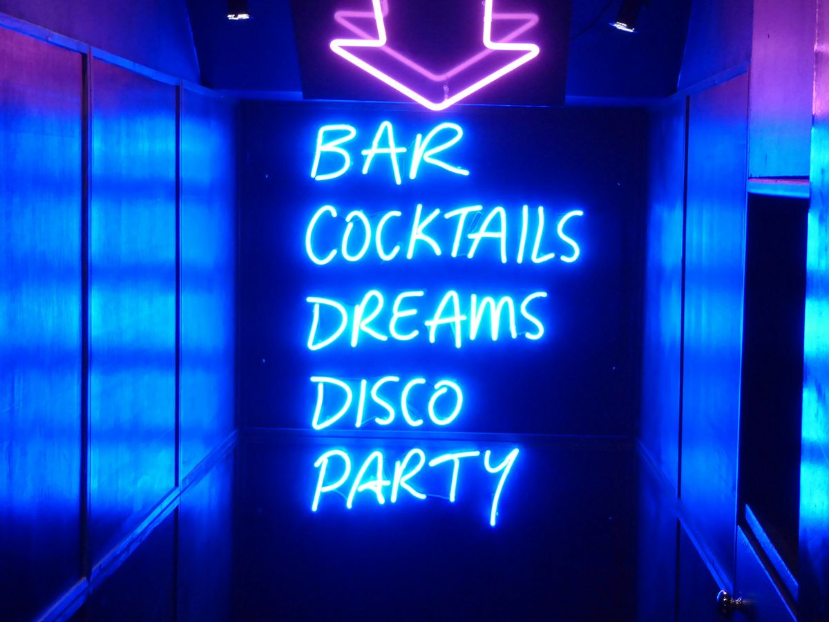 neon sign reading bar cocktails dreams disco party